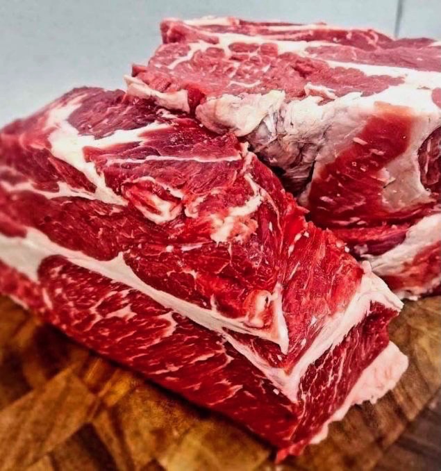 Well-marbled beef cuts resting on a wooden board